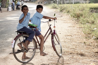 两个男孩白天骑红色踏步自行车